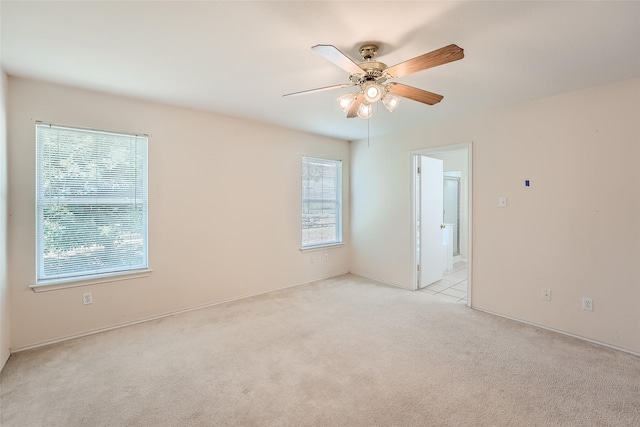 carpeted empty room with ceiling fan and a healthy amount of sunlight