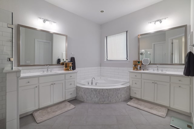 bathroom with vanity, tiled tub, and tile patterned floors