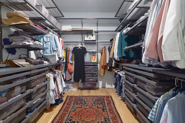 walk in closet with light hardwood / wood-style floors