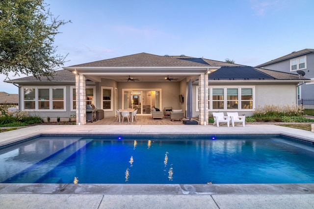 view of swimming pool with ceiling fan, a patio, exterior kitchen, and area for grilling