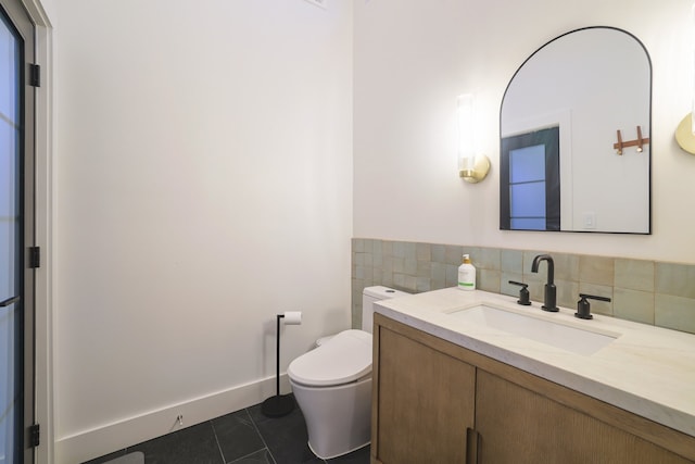 bathroom with toilet, vanity, and tile patterned flooring