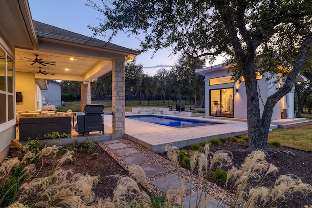 pool at dusk with an outdoor living space, a patio, ceiling fan, and area for grilling