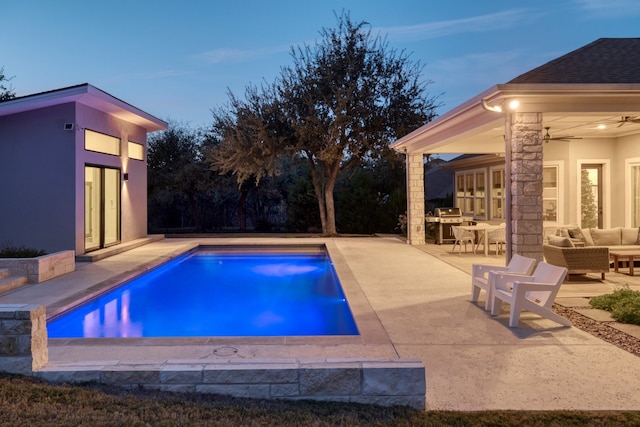 pool at dusk featuring a patio, an outdoor hangout area, and ceiling fan