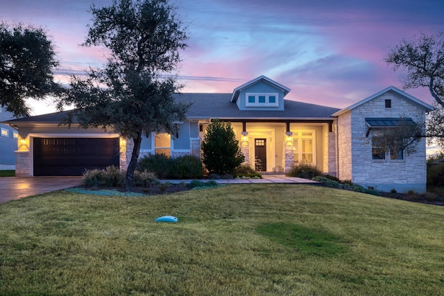 view of front of property with a garage and a yard