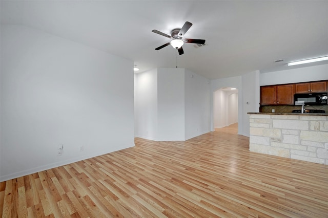 unfurnished living room featuring light wood-type flooring and ceiling fan