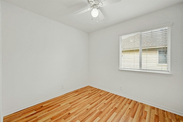 spare room featuring a ceiling fan, baseboards, and light wood finished floors