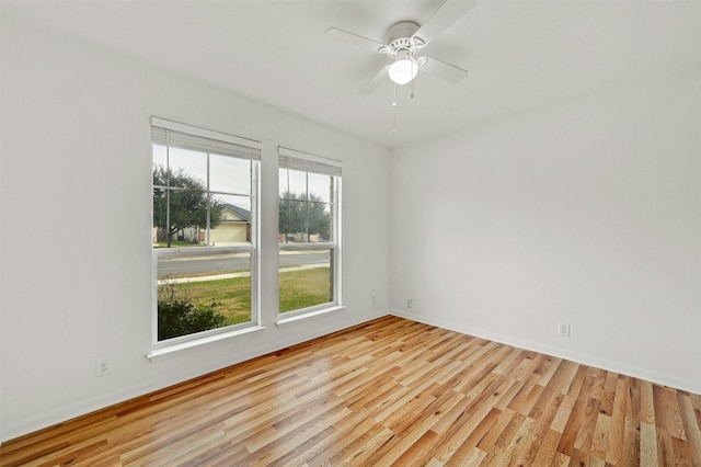 spare room with ceiling fan, baseboards, and light wood-style floors