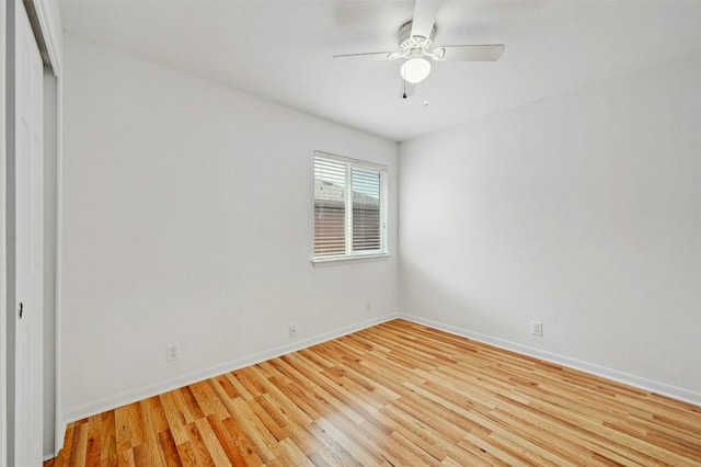 spare room featuring ceiling fan, light wood-type flooring, and baseboards