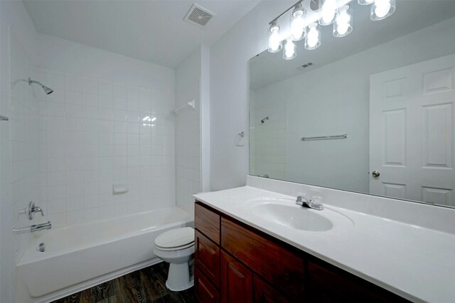 full bathroom featuring vanity, toilet, tiled shower / bath, and wood-type flooring