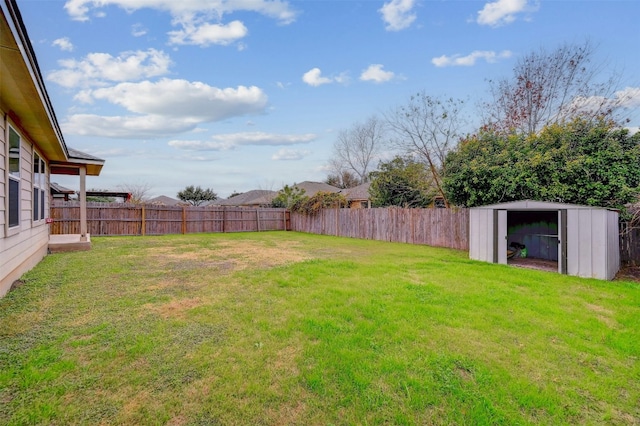 view of yard featuring an outbuilding, a storage unit, and a fenced backyard