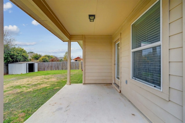 view of patio / terrace with an outbuilding, a storage shed, and fence