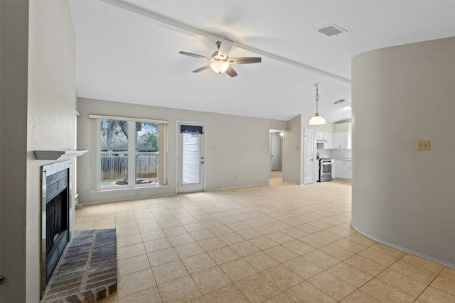 unfurnished living room featuring ceiling fan, beam ceiling, a fireplace, and light tile patterned flooring