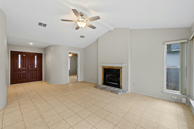 unfurnished living room with a brick fireplace, a wealth of natural light, ceiling fan, and vaulted ceiling with beams