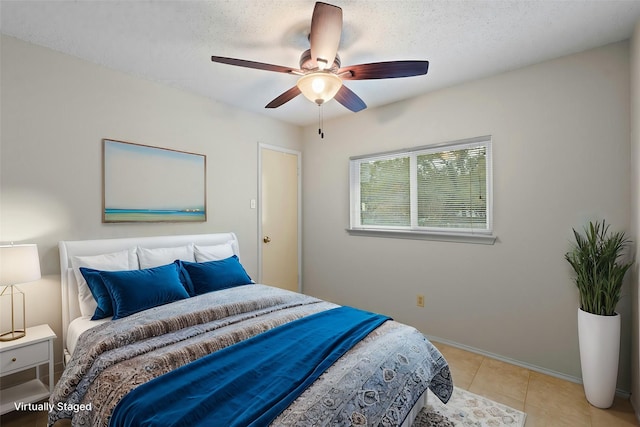 tiled bedroom featuring ceiling fan and a textured ceiling