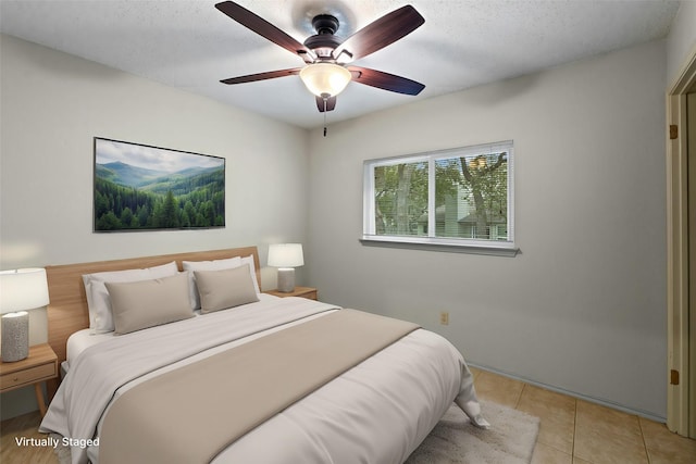 tiled bedroom with ceiling fan and a textured ceiling