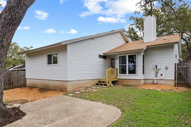 back of property with a lawn and a patio