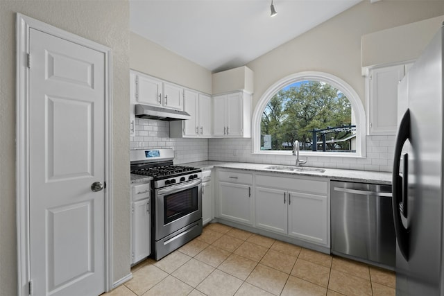 kitchen featuring sink, tasteful backsplash, white cabinetry, light tile patterned floors, and stainless steel appliances