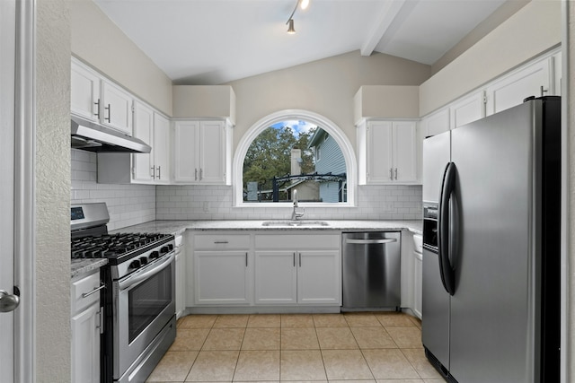 kitchen with decorative backsplash, white cabinets, appliances with stainless steel finishes, and lofted ceiling with beams