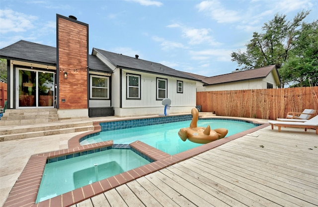 view of pool with an in ground hot tub and a deck