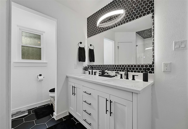 bathroom with tiled shower, toilet, tile patterned floors, and vanity