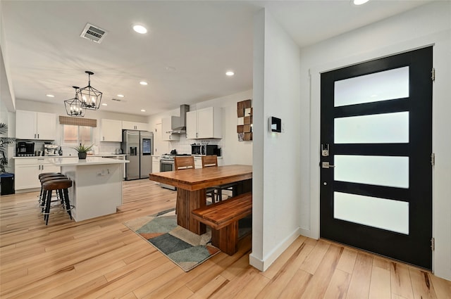 kitchen featuring a breakfast bar area, white cabinetry, a center island, and appliances with stainless steel finishes