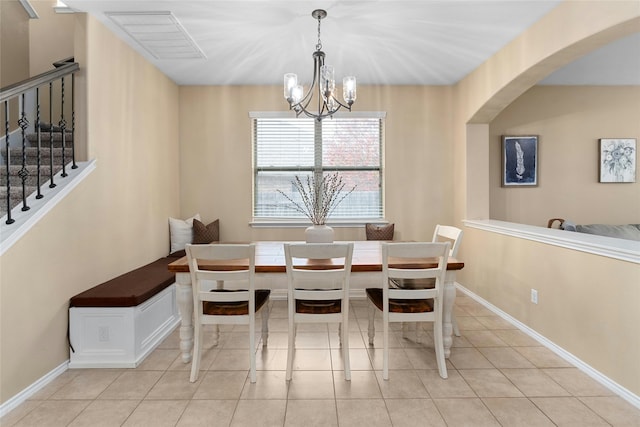 tiled dining room featuring breakfast area and a chandelier