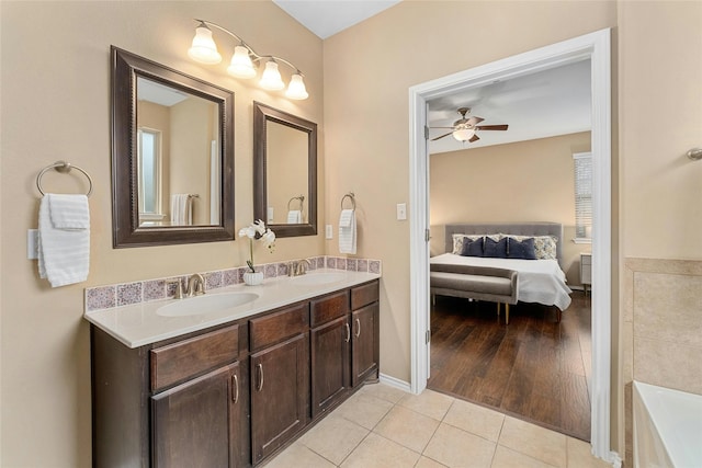 bathroom featuring ceiling fan, vanity, a bathing tub, and tile patterned flooring