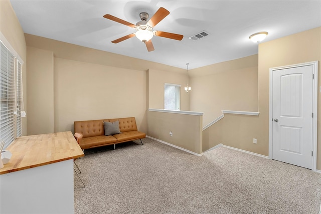 living area featuring ceiling fan and carpet flooring