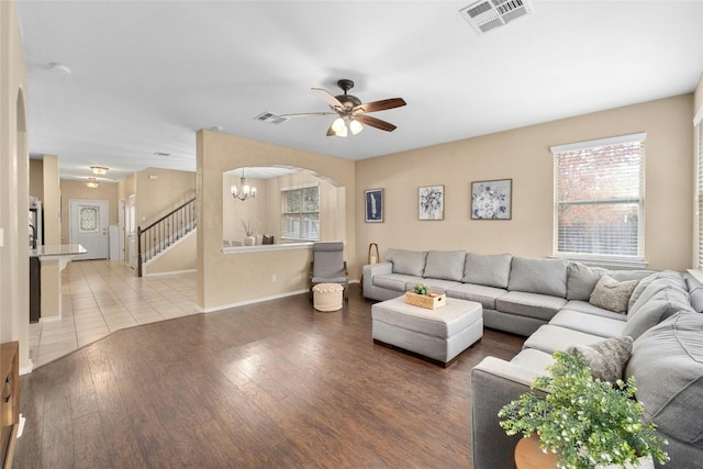 9201 Bentley Garner Ln, Austin, TX 78748 - living room featuring arched walkways, a ceiling fan, a chandelier, wood finished floors, and stairs