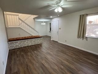 interior space with ceiling fan with notable chandelier and dark wood-type flooring