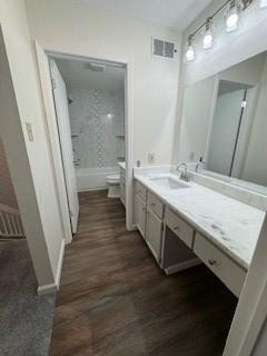 full bathroom with tub / shower combination, hardwood / wood-style flooring, toilet, and vanity