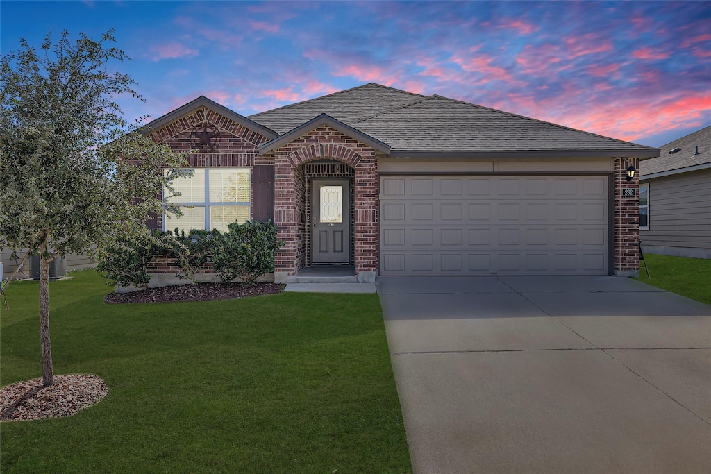 view of front of house with a garage and a yard