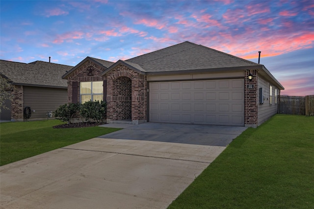 ranch-style house featuring a garage and a yard