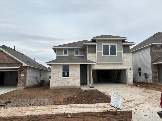 view of front of home with central AC unit and a garage