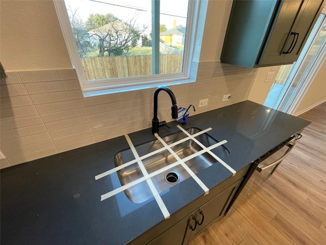 room details with decorative backsplash and light hardwood / wood-style flooring