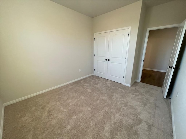 unfurnished bedroom featuring light colored carpet and a closet