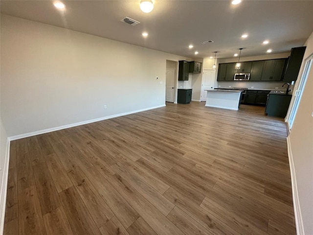 unfurnished living room with dark hardwood / wood-style flooring and sink