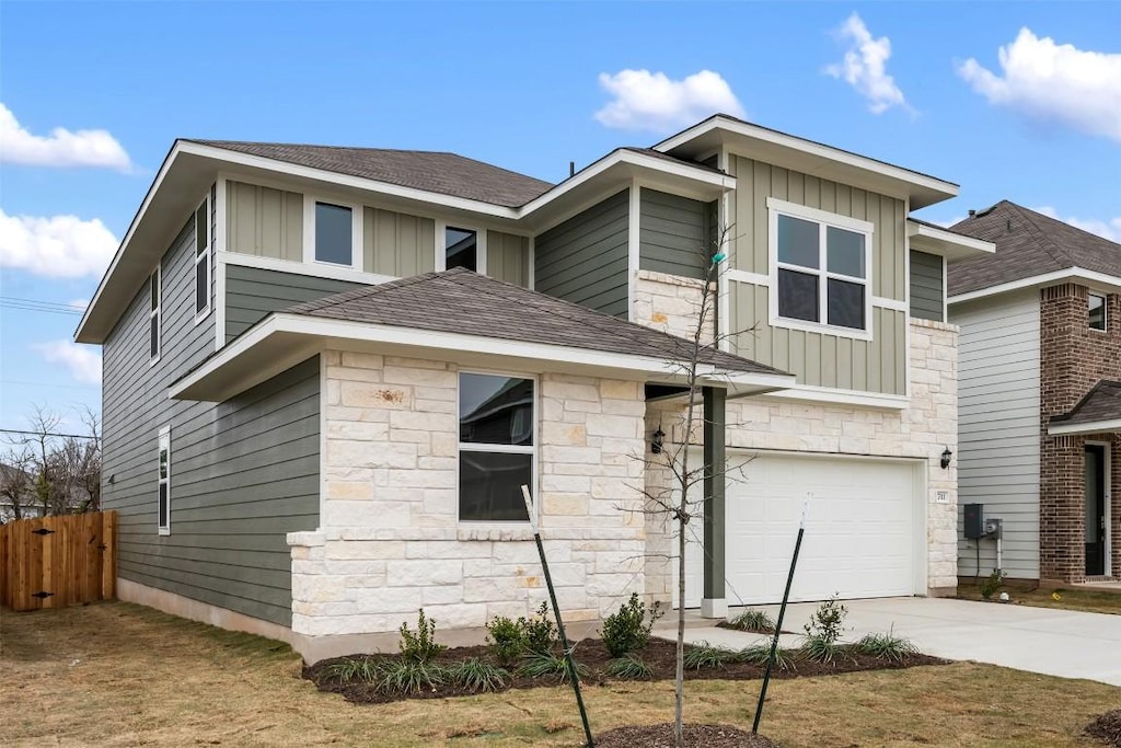 exterior space with a garage, stone siding, board and batten siding, and concrete driveway