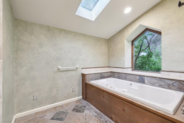 bathroom featuring a washtub and a skylight