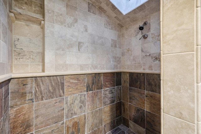 room details featuring tiled shower and a skylight