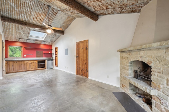 unfurnished living room with concrete floors, a skylight, high vaulted ceiling, beam ceiling, and wine cooler