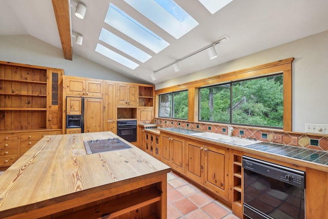 kitchen featuring light tile patterned floors, black appliances, lofted ceiling with beams, and wooden counters