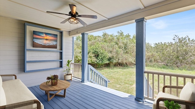 wooden terrace with ceiling fan and a yard