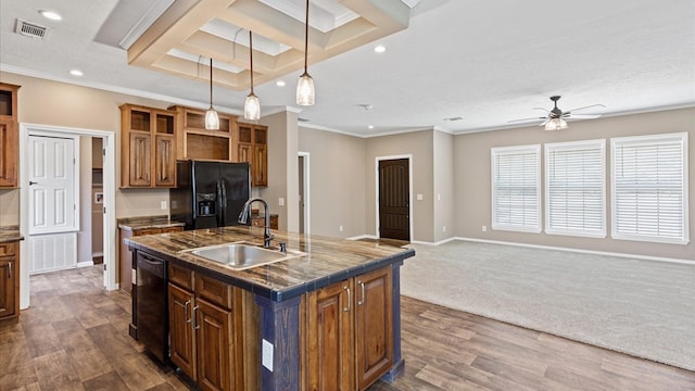 kitchen featuring black appliances, decorative light fixtures, an island with sink, sink, and crown molding