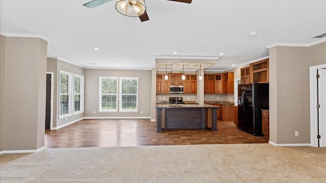 kitchen with a kitchen island, dark colored carpet, black refrigerator with ice dispenser, and crown molding