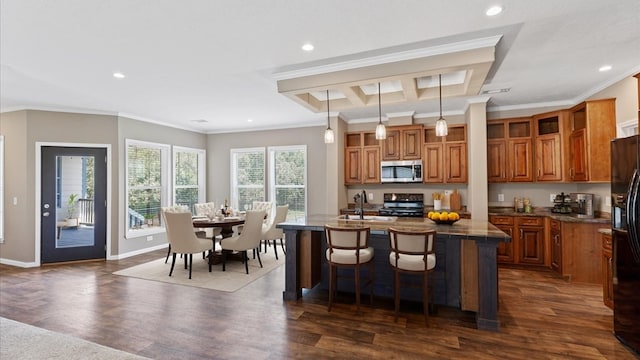 kitchen featuring pendant lighting, an island with sink, a kitchen bar, electric range oven, and ornamental molding