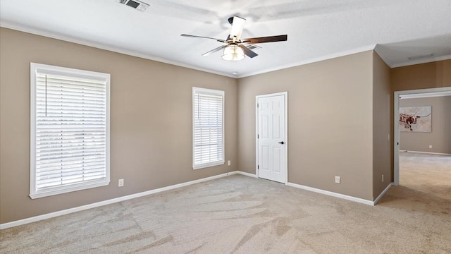 carpeted spare room with ceiling fan and crown molding