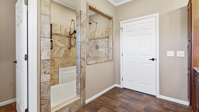 bathroom featuring a tile shower, wood-type flooring, and crown molding