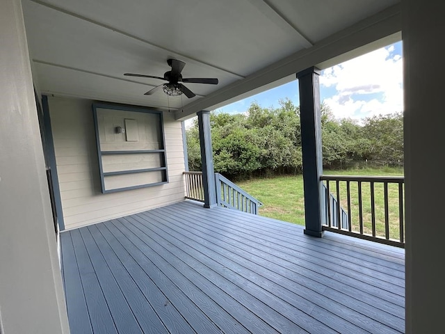 wooden terrace featuring a lawn and ceiling fan