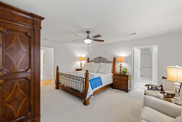 bedroom with ceiling fan, light carpet, and ensuite bath